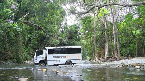Tour bus going through creek near Bloomfield Track Cooktown