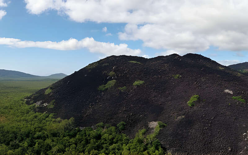 Black Mountain Kalkajaka rising above surrounding green scrubland, south of Cooktown, Far North Queensland