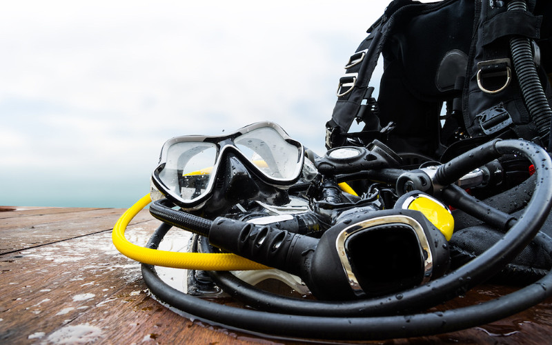 Scuba diving equipment including mask, regulator and tank on boat deck at the Great Barrier Reef