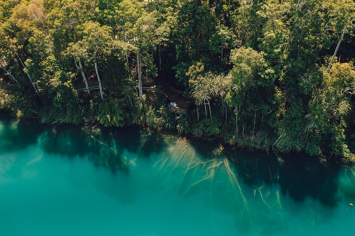 `Aerial view of crystal clear turquoise water at Lake Eacham volcanic crater lake Atherton Tablelands Queensland`